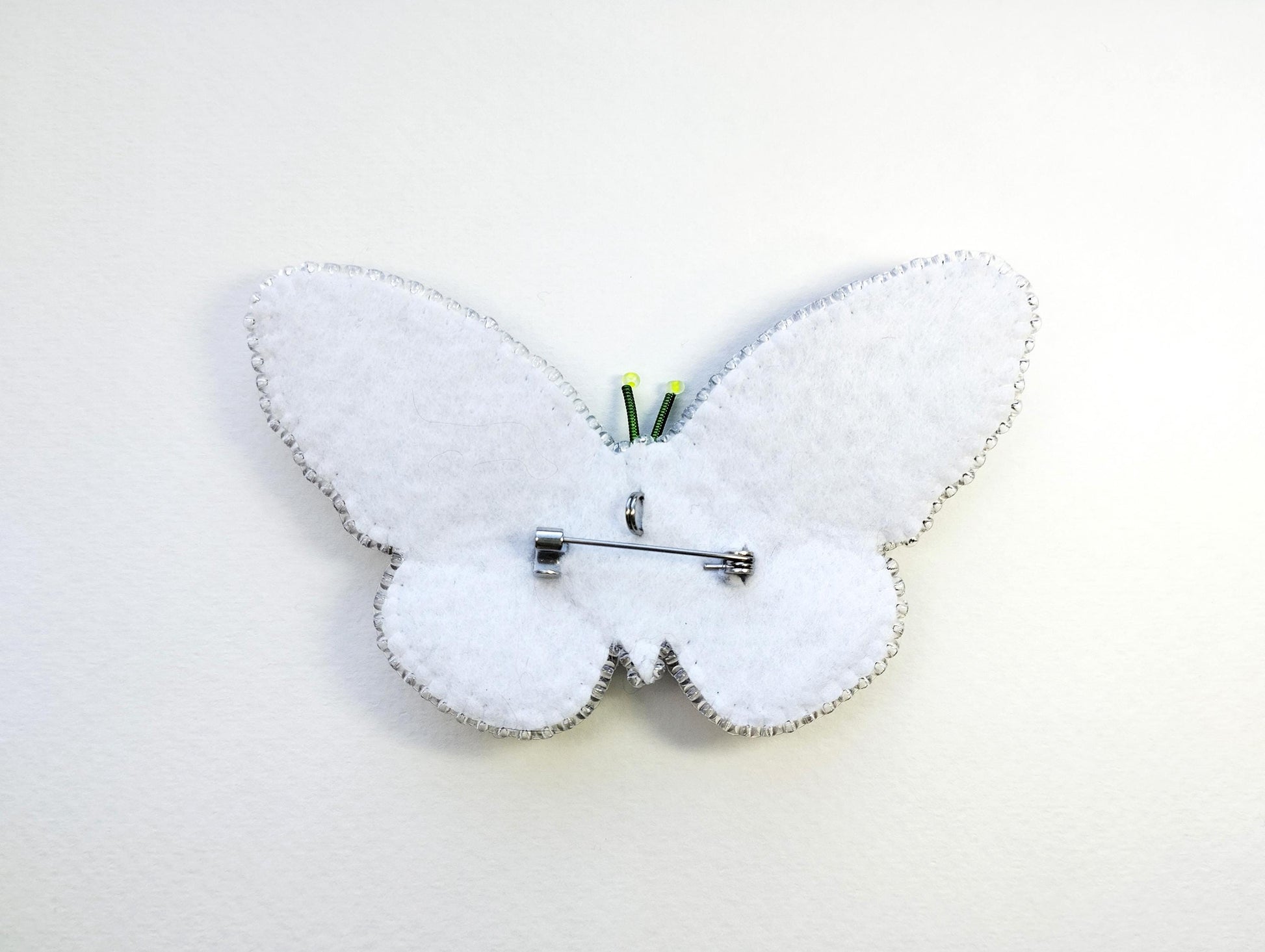 a white clock with a butterfly design on it