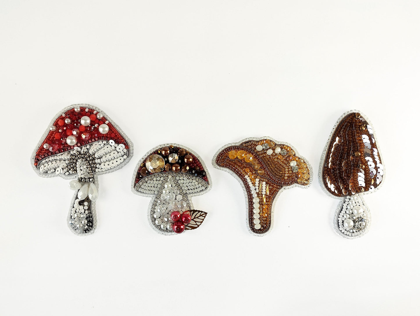 a group of three brooches sitting on top of a white surface