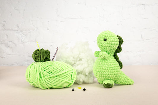 two crocheted toys sitting next to each other on a table