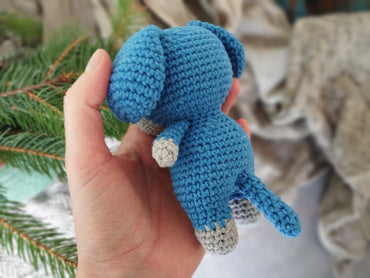 a hand holding a small crocheted stuffed animal