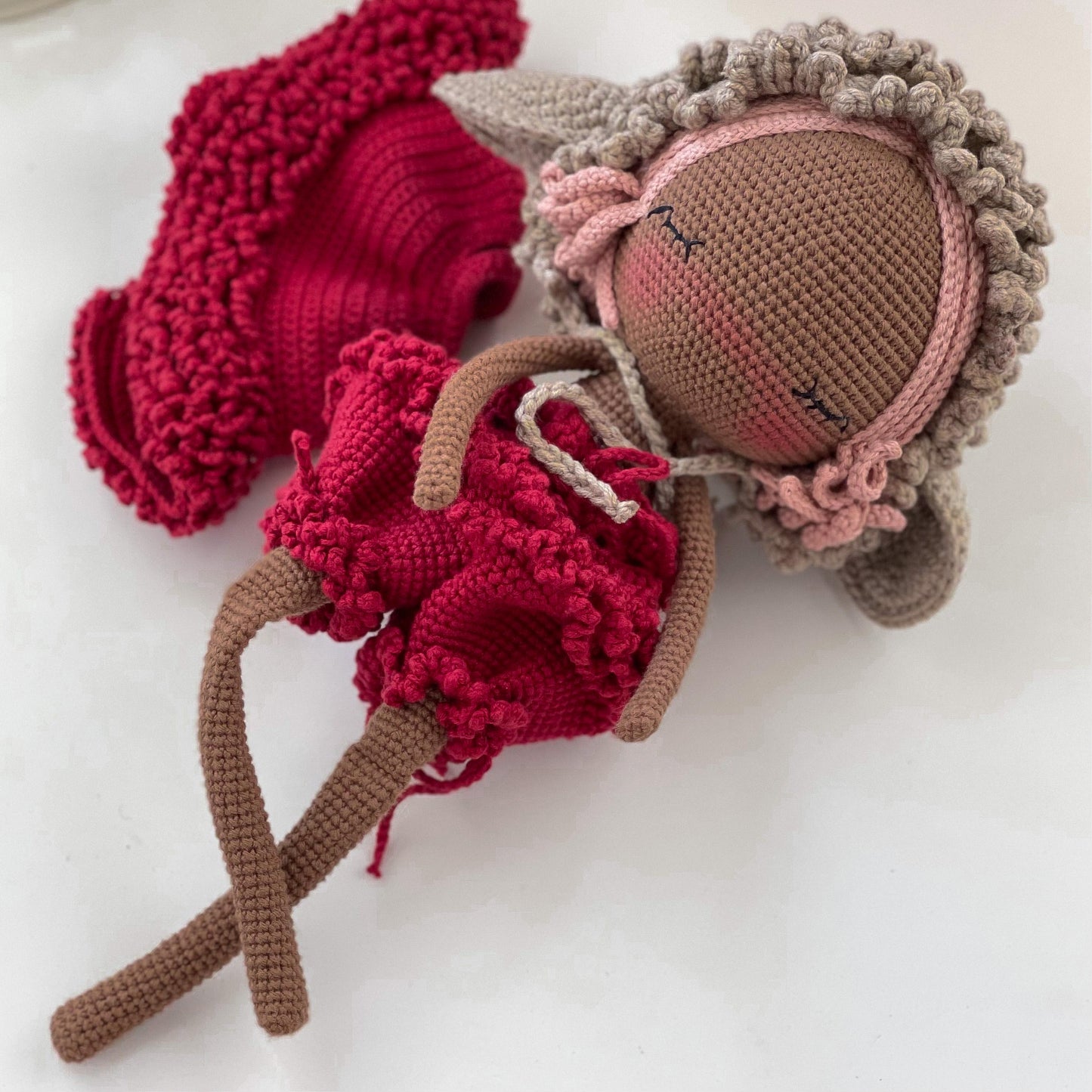 a crocheted doll and a crocheted doll on a white surface