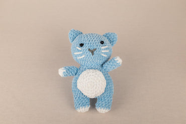 a crocheted blue cat with a white belly