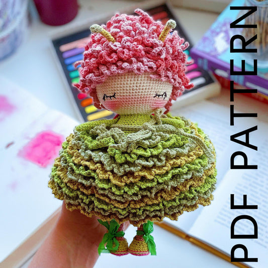 a crocheted doll is sitting on a table