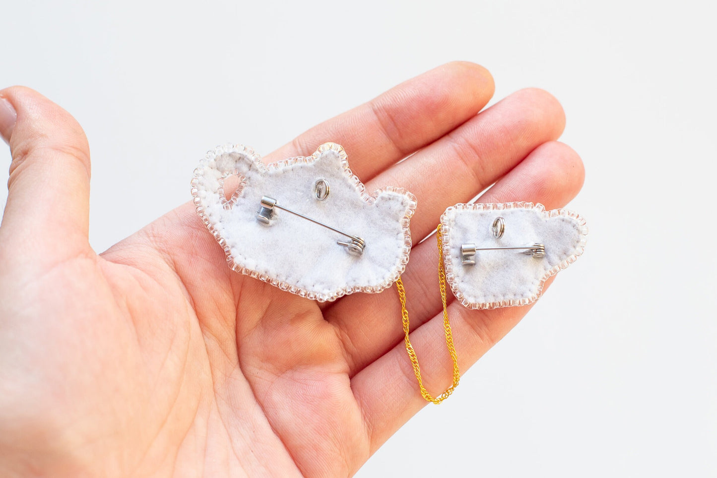 a hand holding a pair of earrings in it's palm