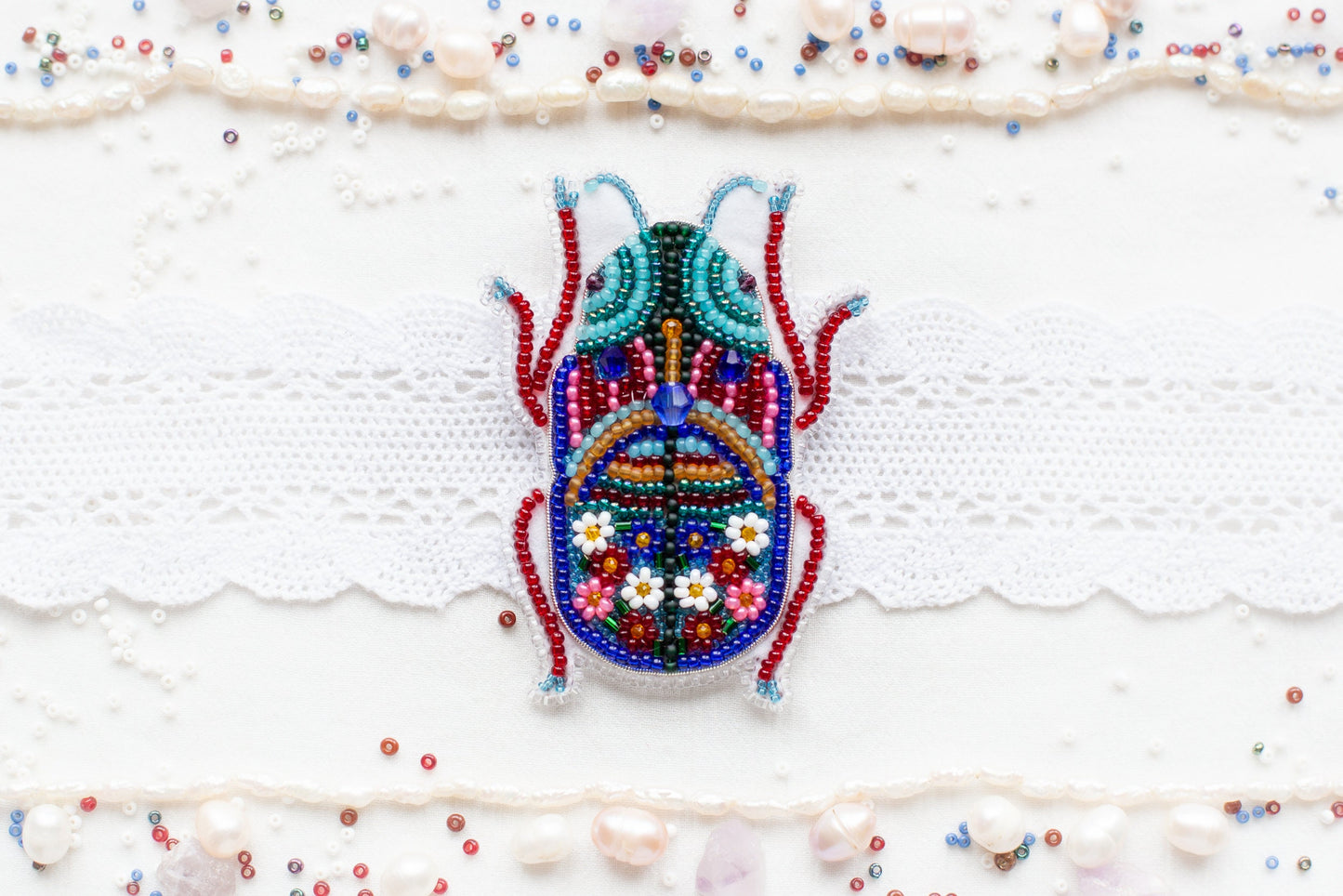 a beaded bug is sitting on a white surface