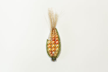 a beaded corn cob hanging on a wall