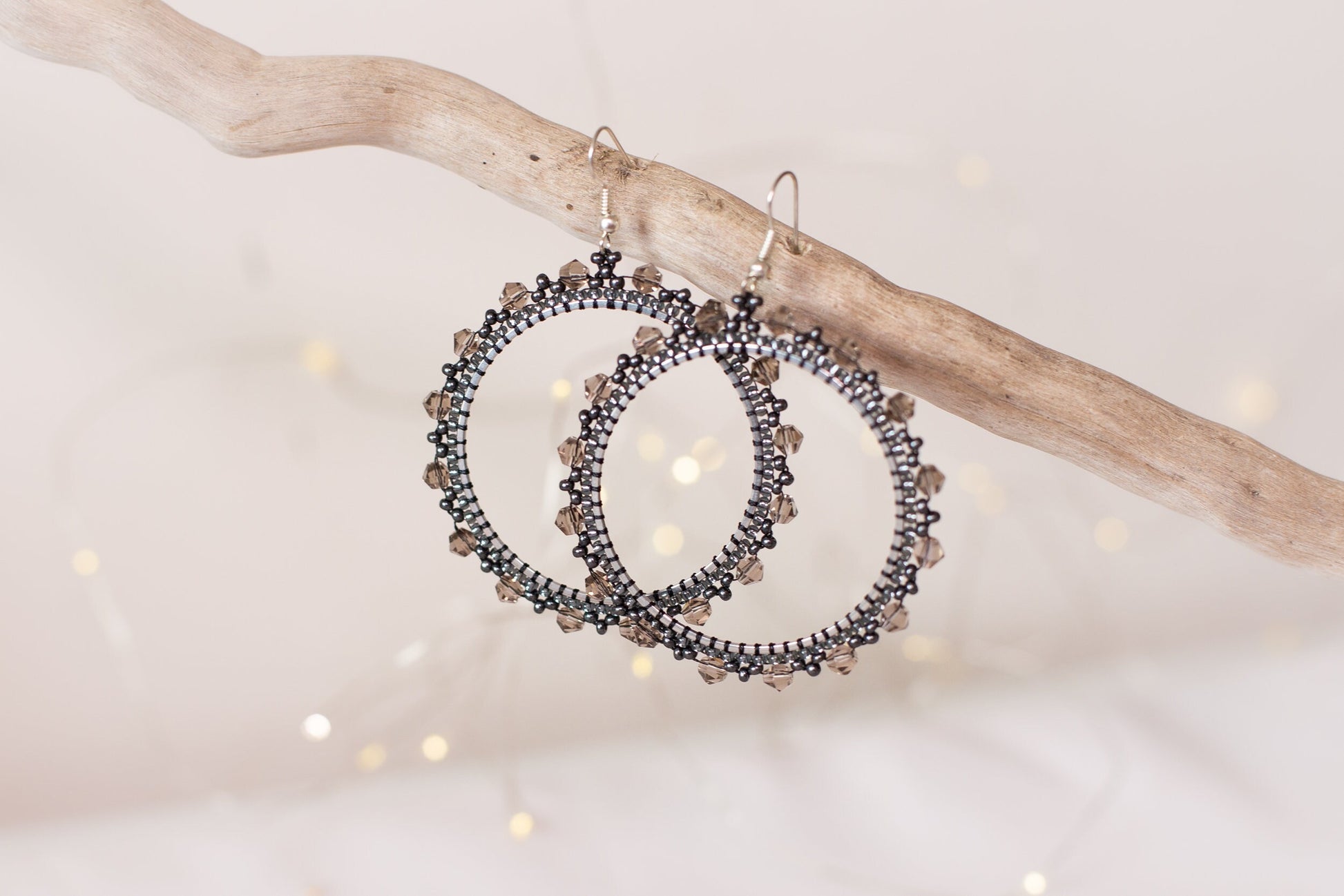 a pair of earrings hanging from a tree branch