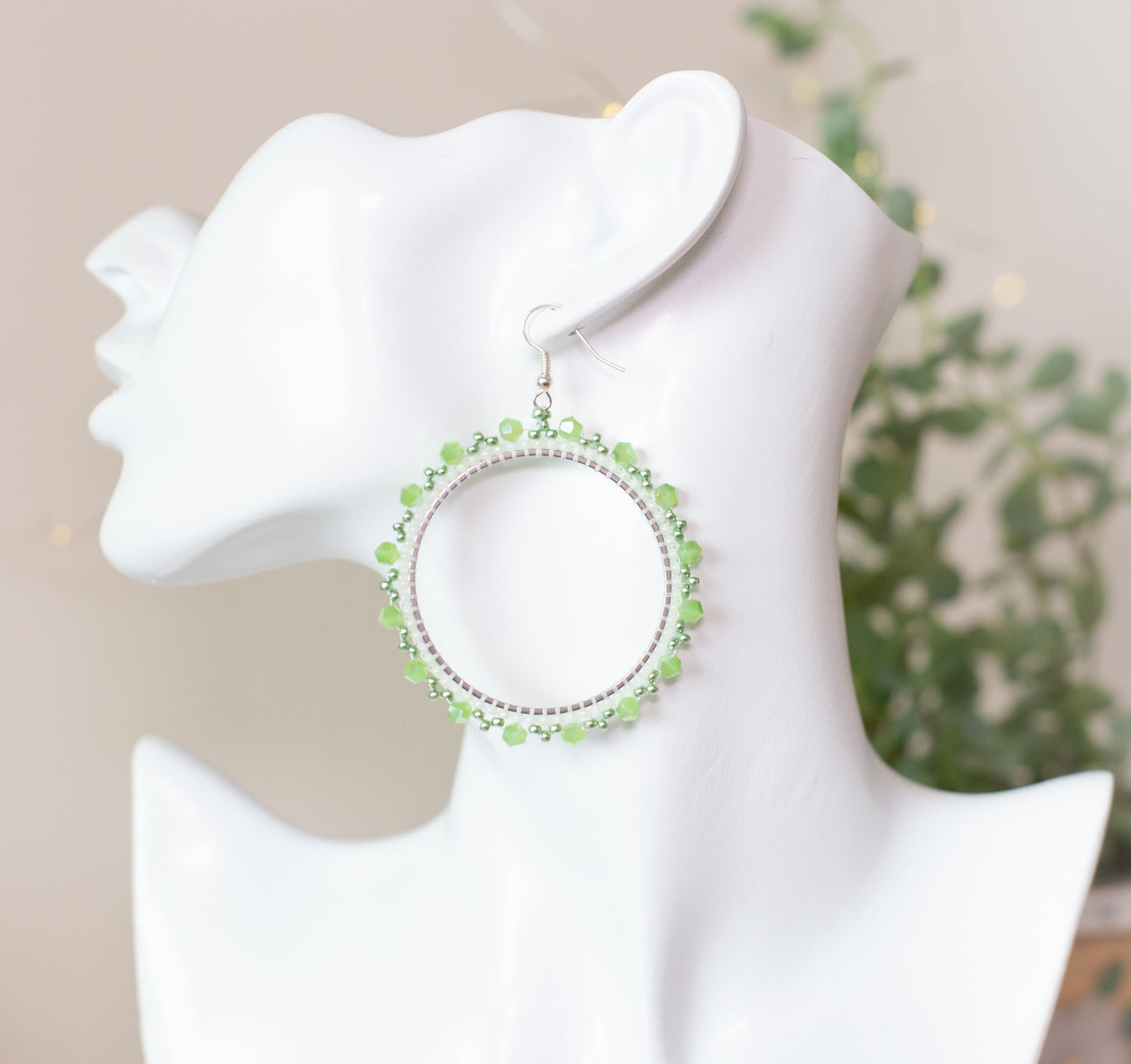 a white mannequin head with a pair of earrings on it