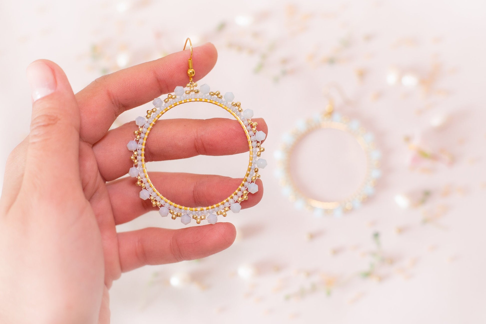 a person holding a pair of earrings in their hand