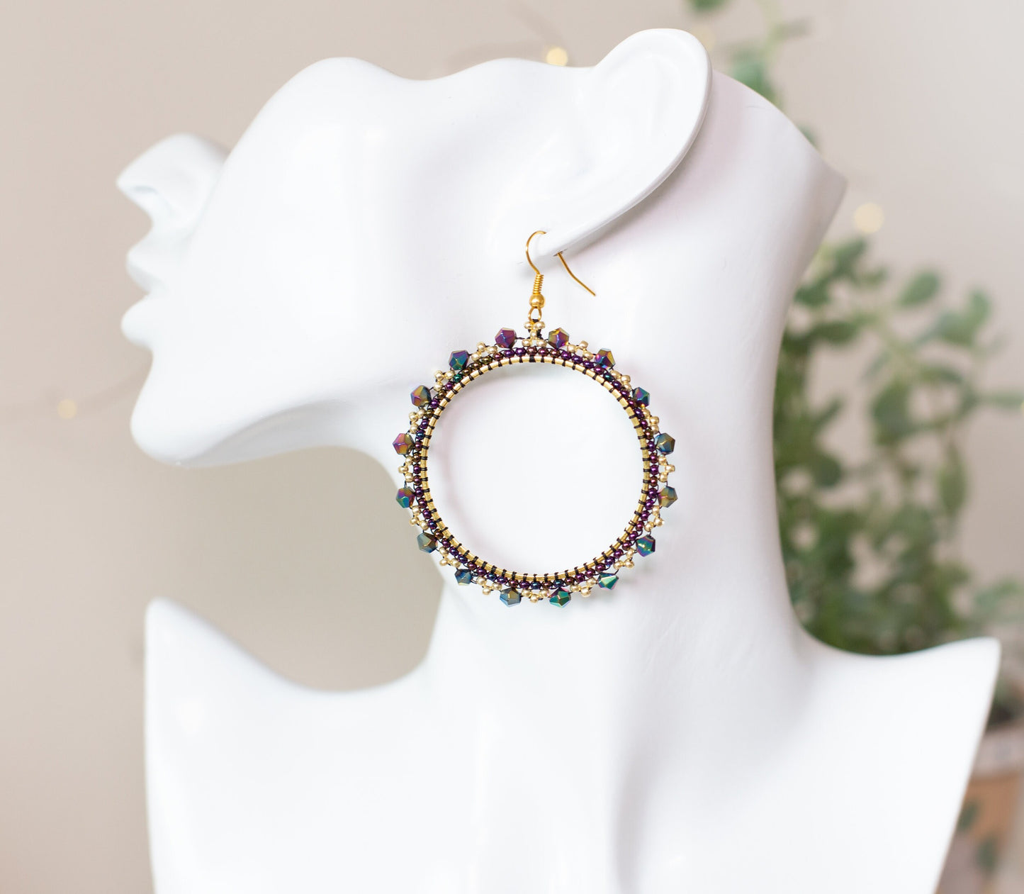 a white mannequin head with a pair of earrings on it