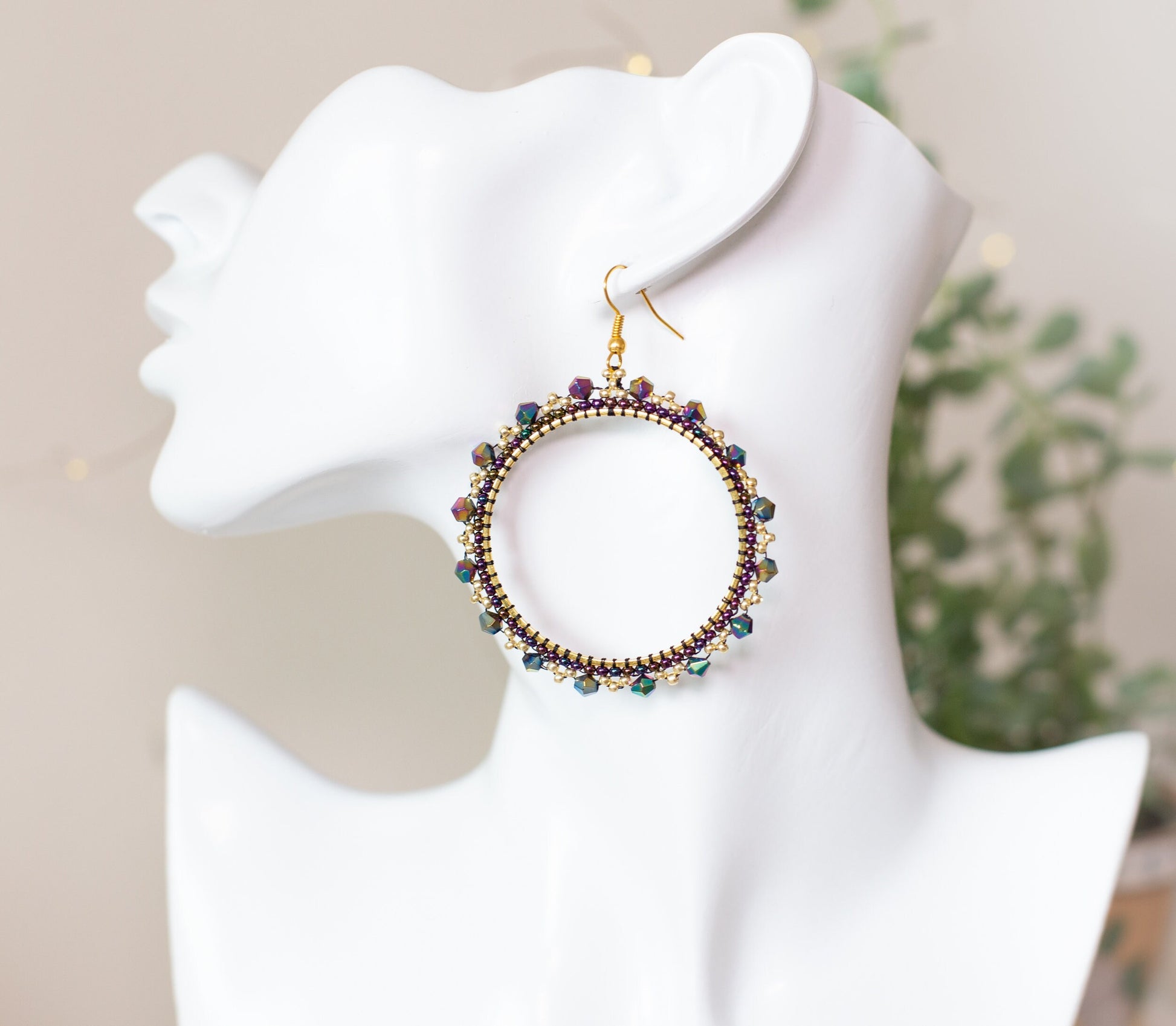 a white mannequin head with a pair of earrings on it