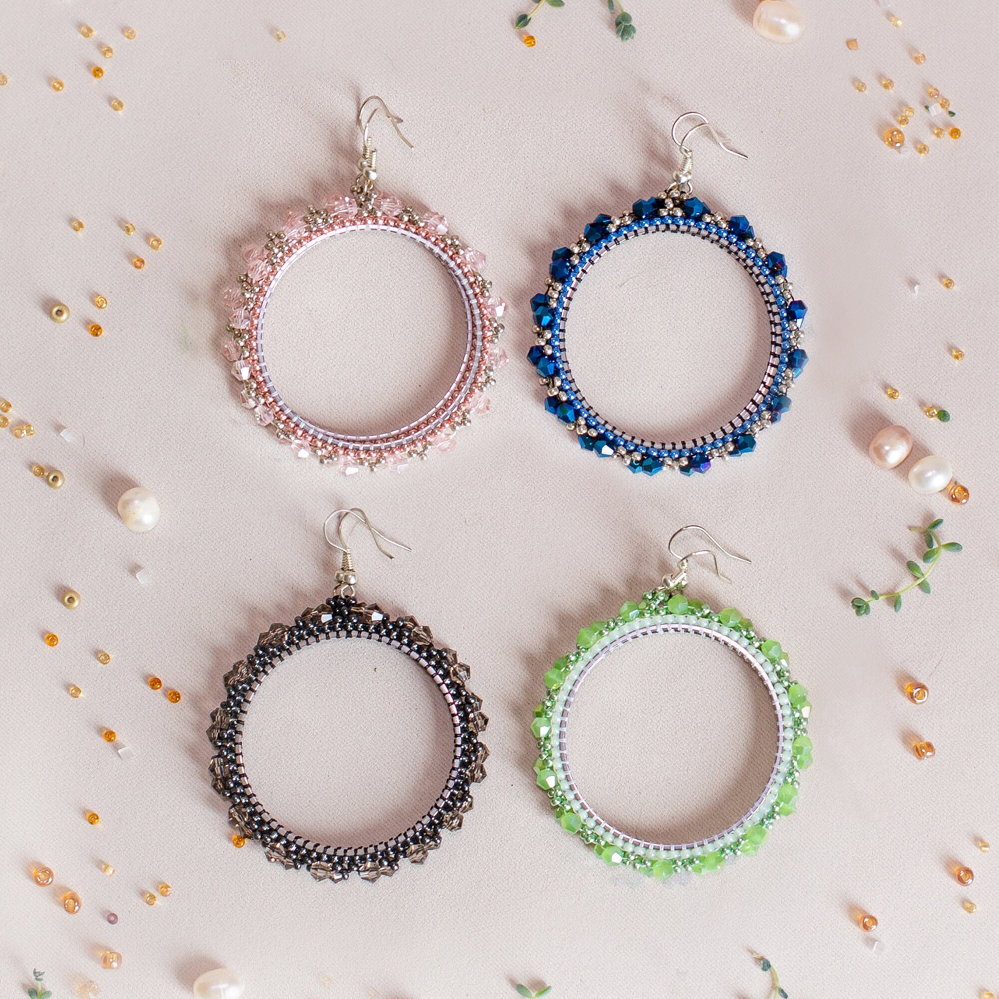 six pairs of beaded hoop earrings on a white background
