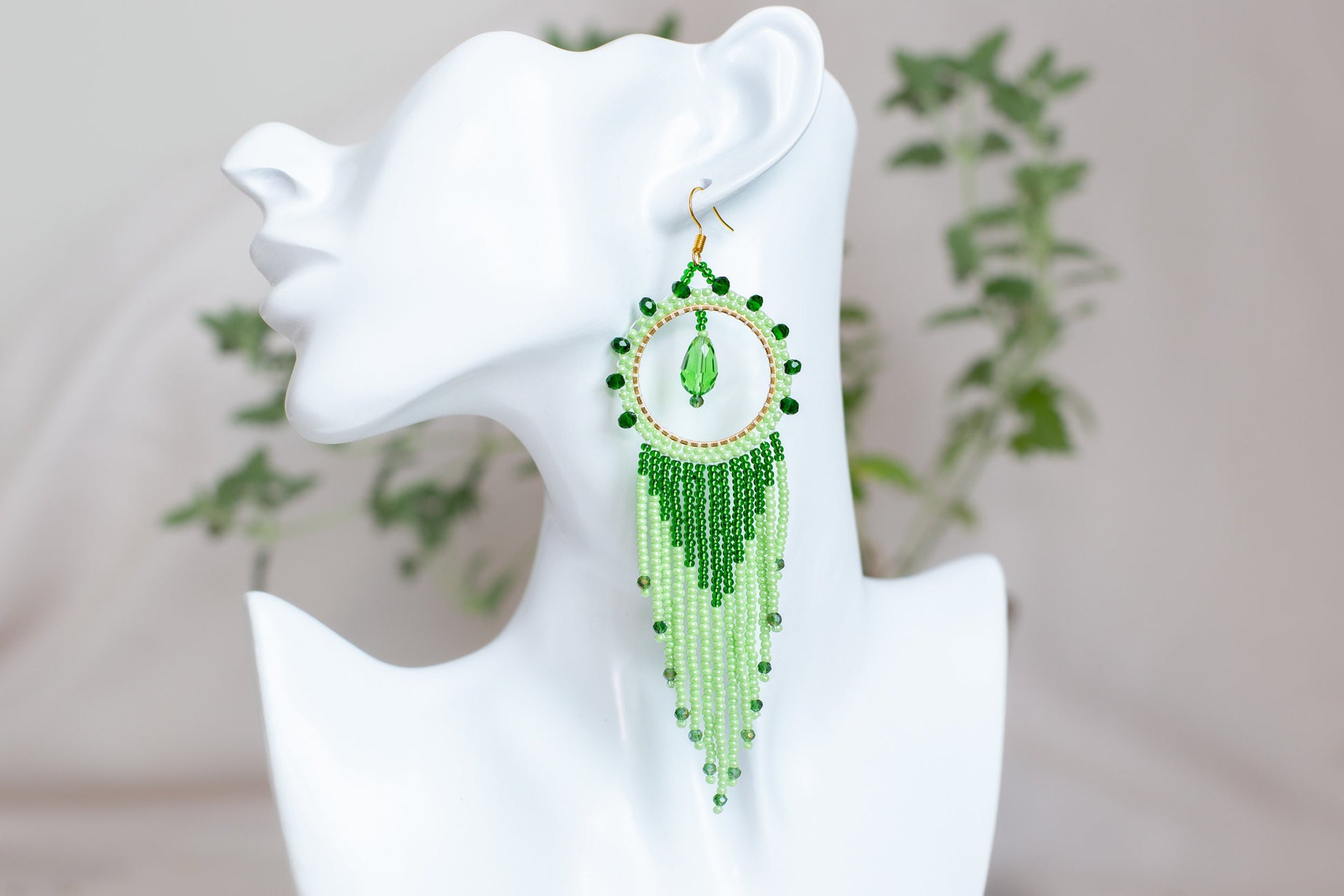 a close up of a pair of earrings on a mannequin head