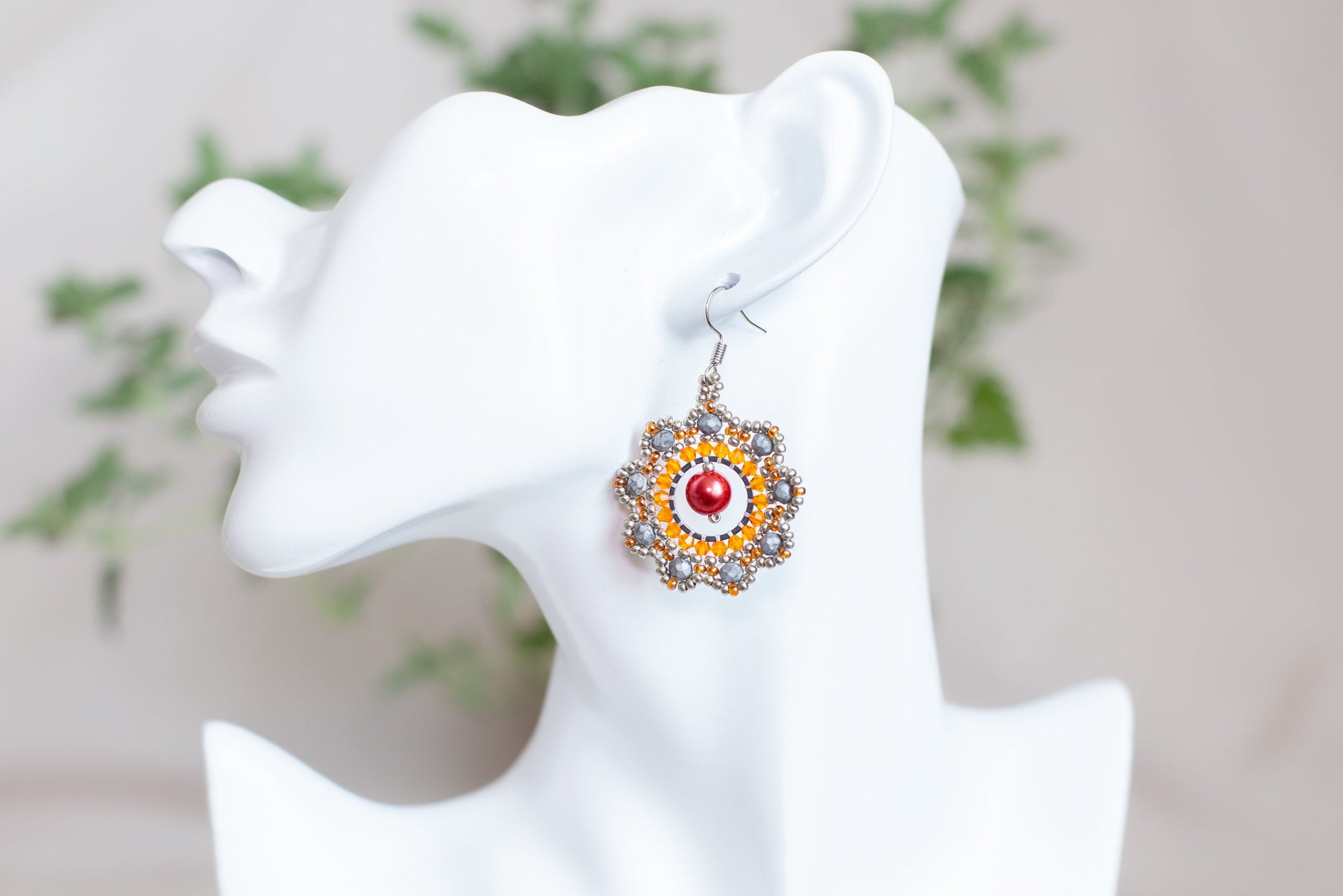 a close up of a pair of earrings on a mannequin head