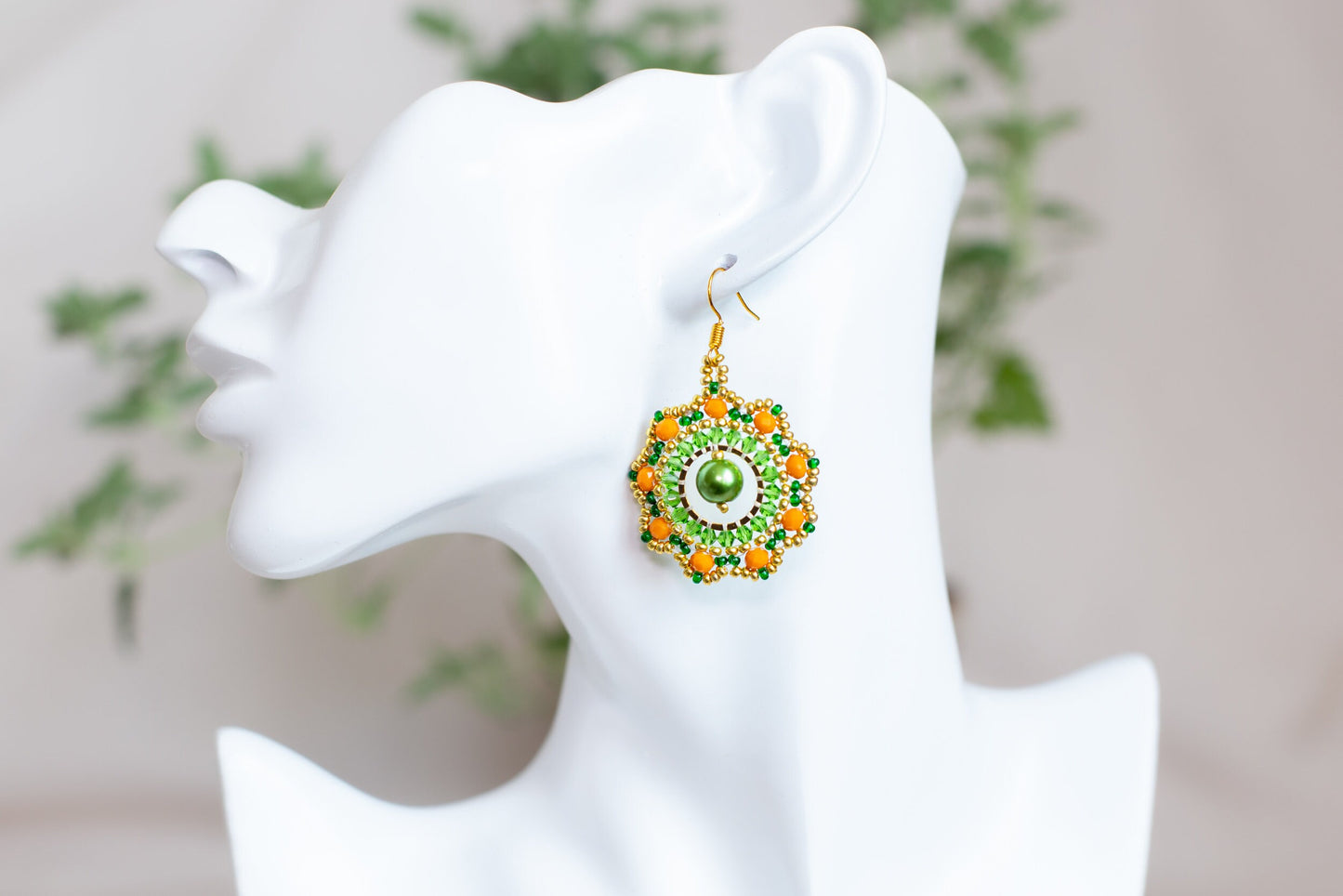 a close up of a pair of earrings on a mannequin head