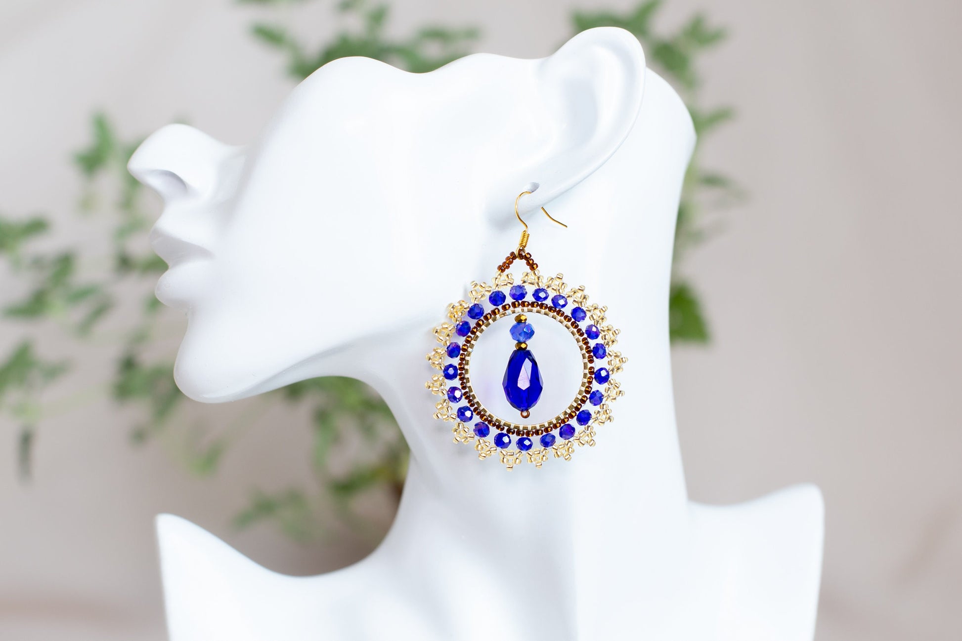 a close up of a pair of earrings on a mannequin head