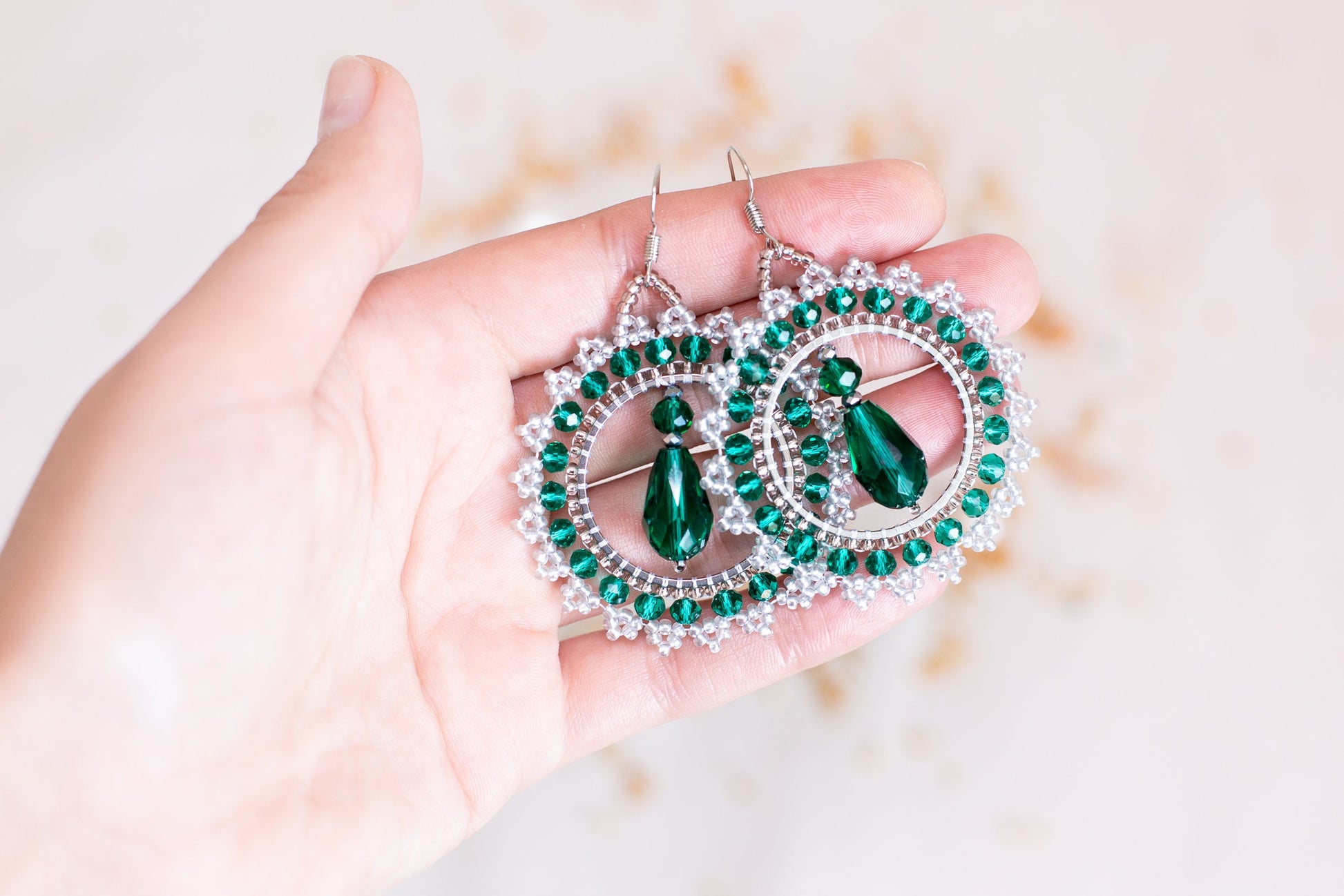 a person holding a pair of earrings in their hand