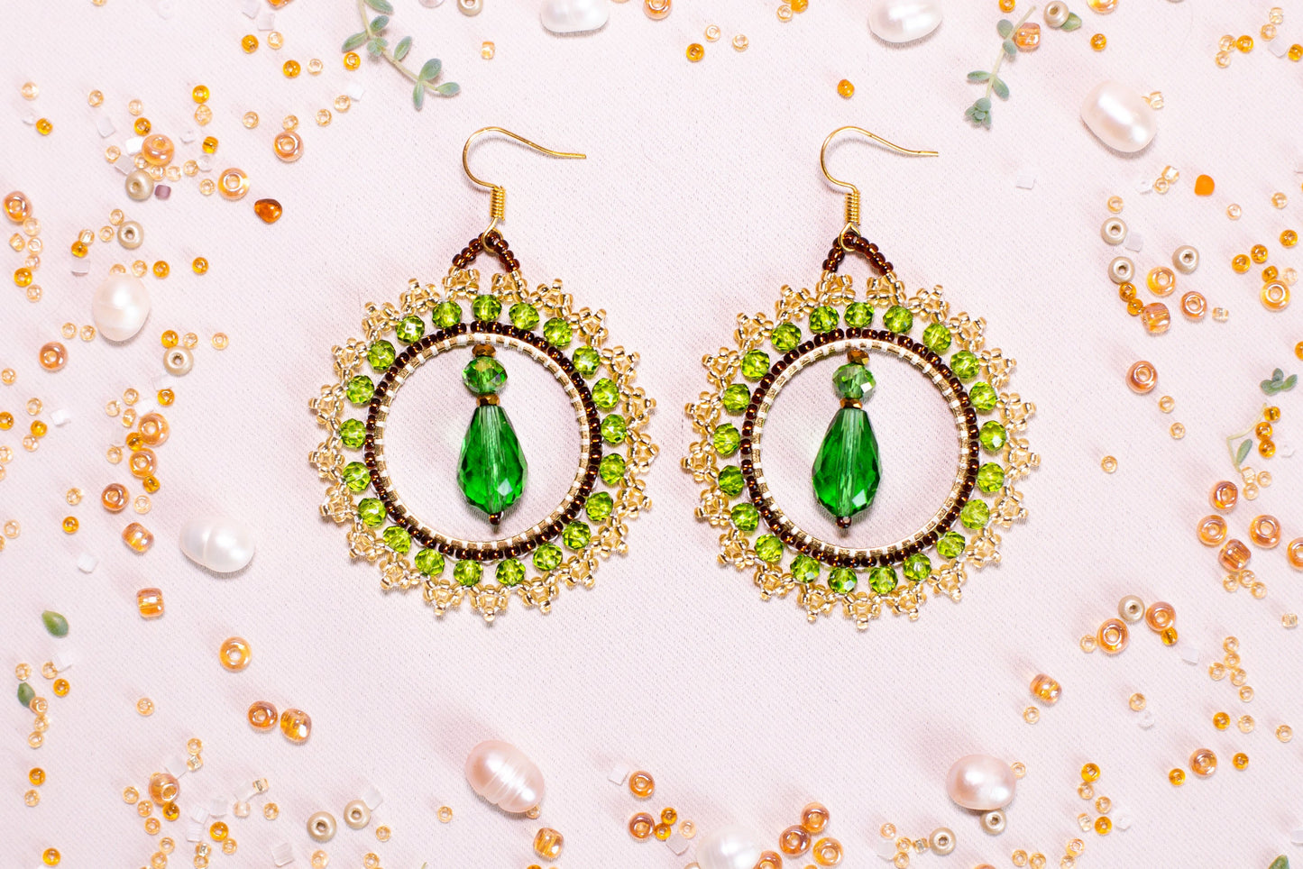 a pair of earrings with a green beaded design