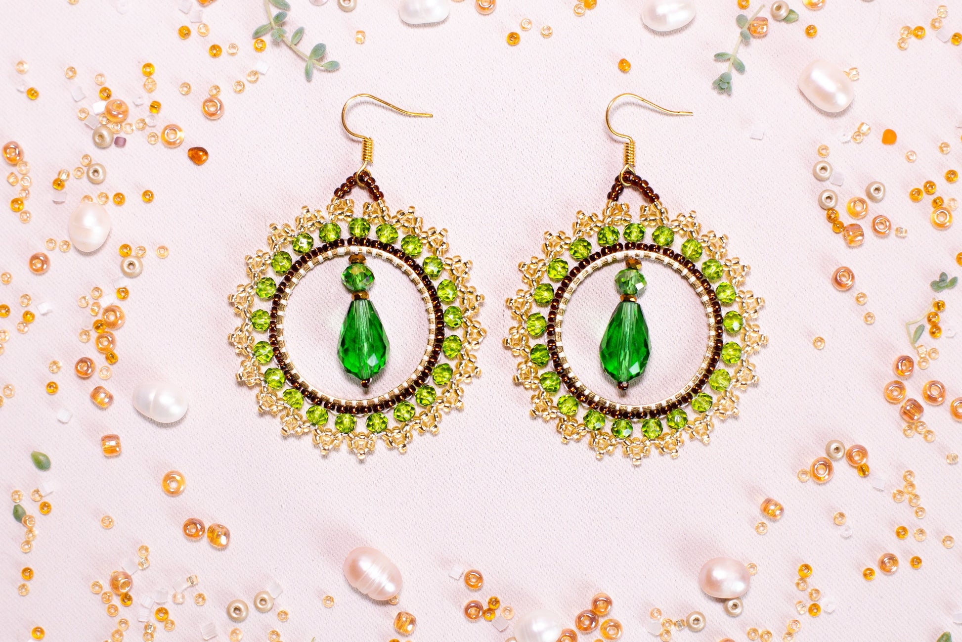a pair of earrings with a green beaded design