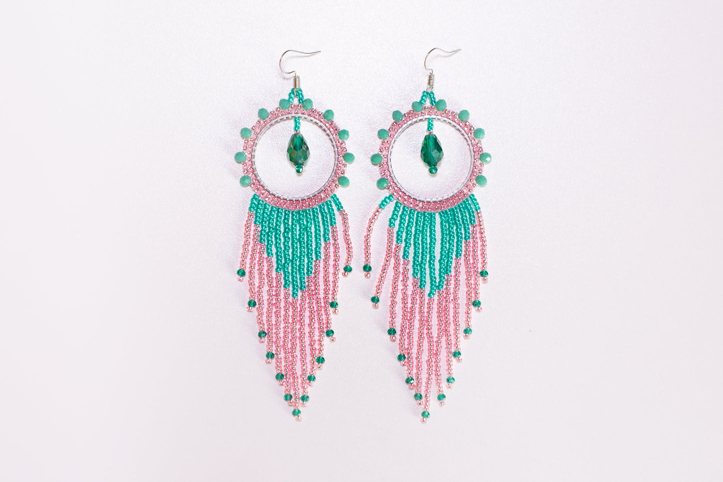 a person holding a pair of earrings in their hand