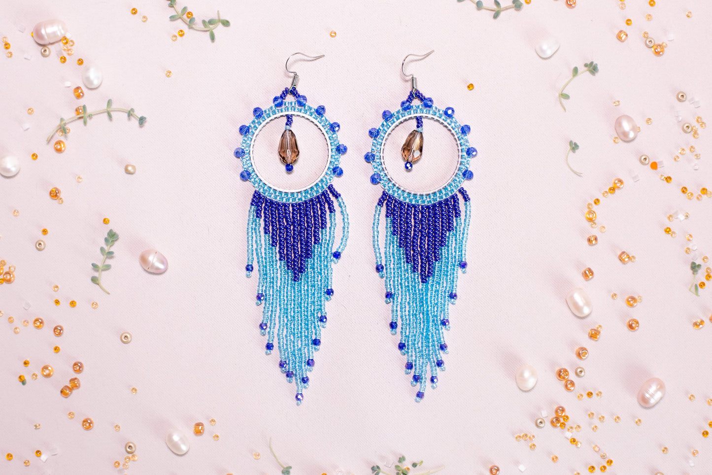 a pair of blue beaded earrings sitting on top of a table