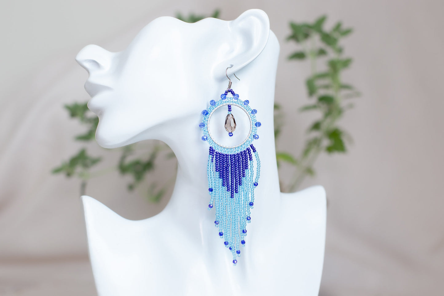 a close up of a pair of earrings on a mannequin head