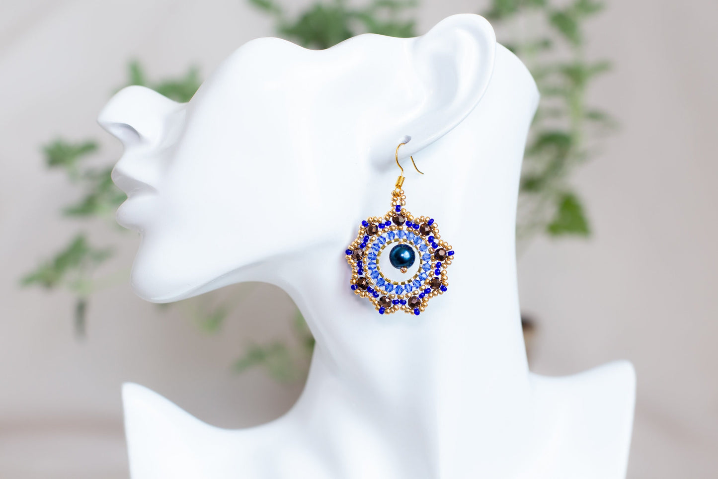 a white mannequin head with a pair of earrings on it