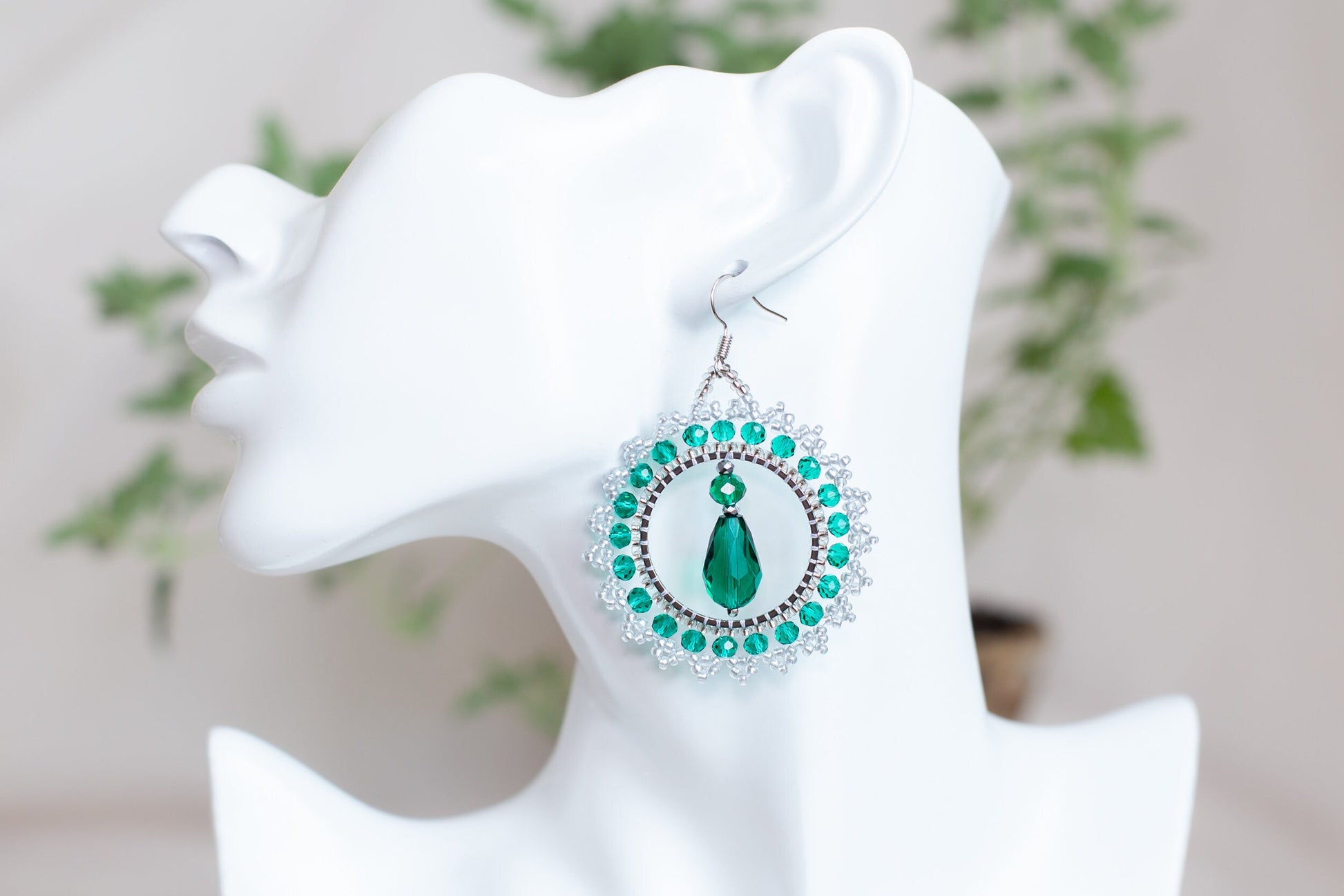 a close up of a pair of earrings on a mannequin head