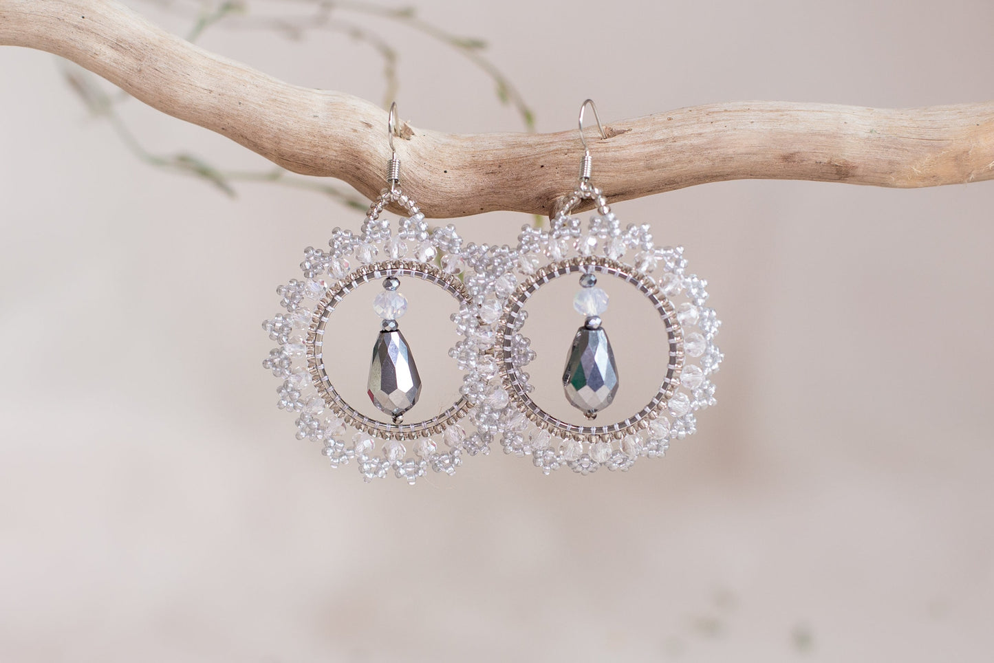 a pair of earrings hanging from a tree branch