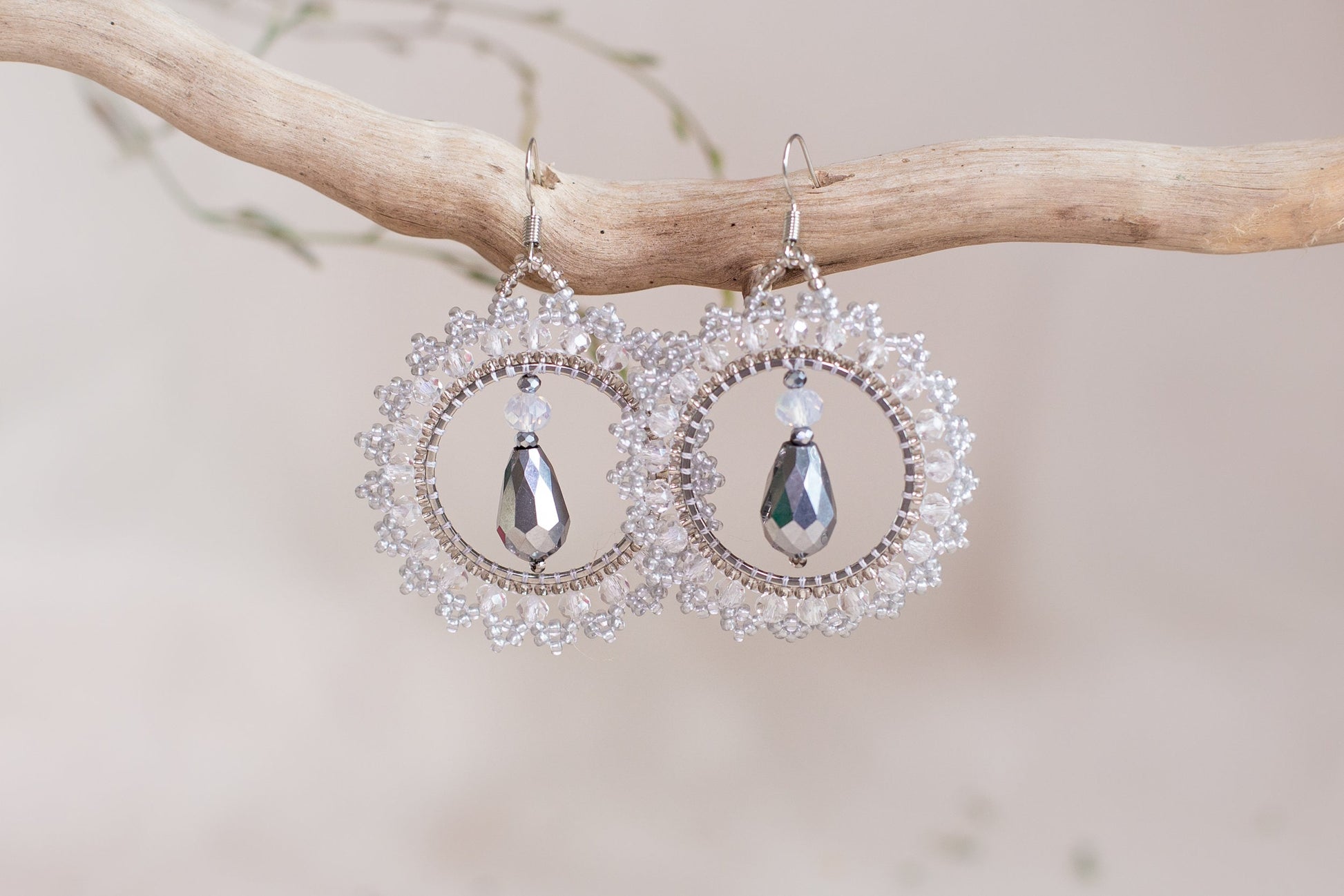 a pair of earrings hanging from a tree branch