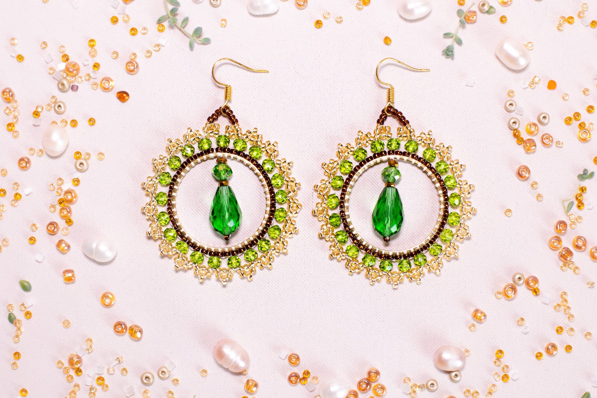 a pair of earrings with a green beaded design
