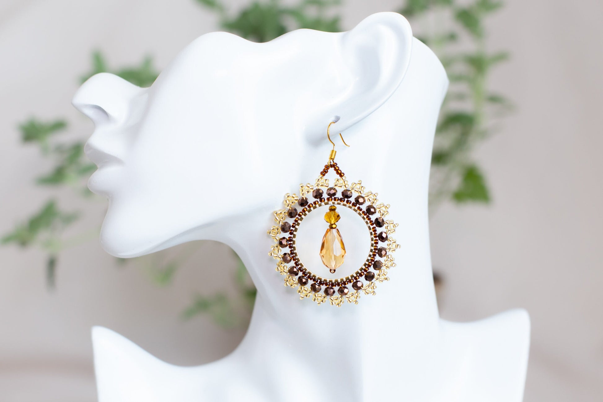 a white mannequin head with a pair of earrings on it