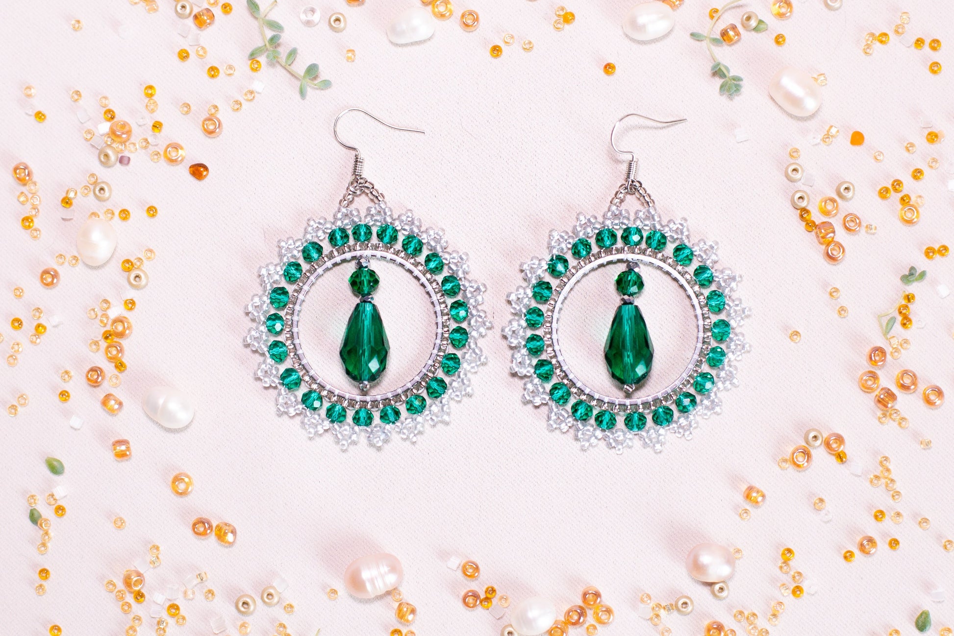 a pair of green and white earrings sitting on top of a table