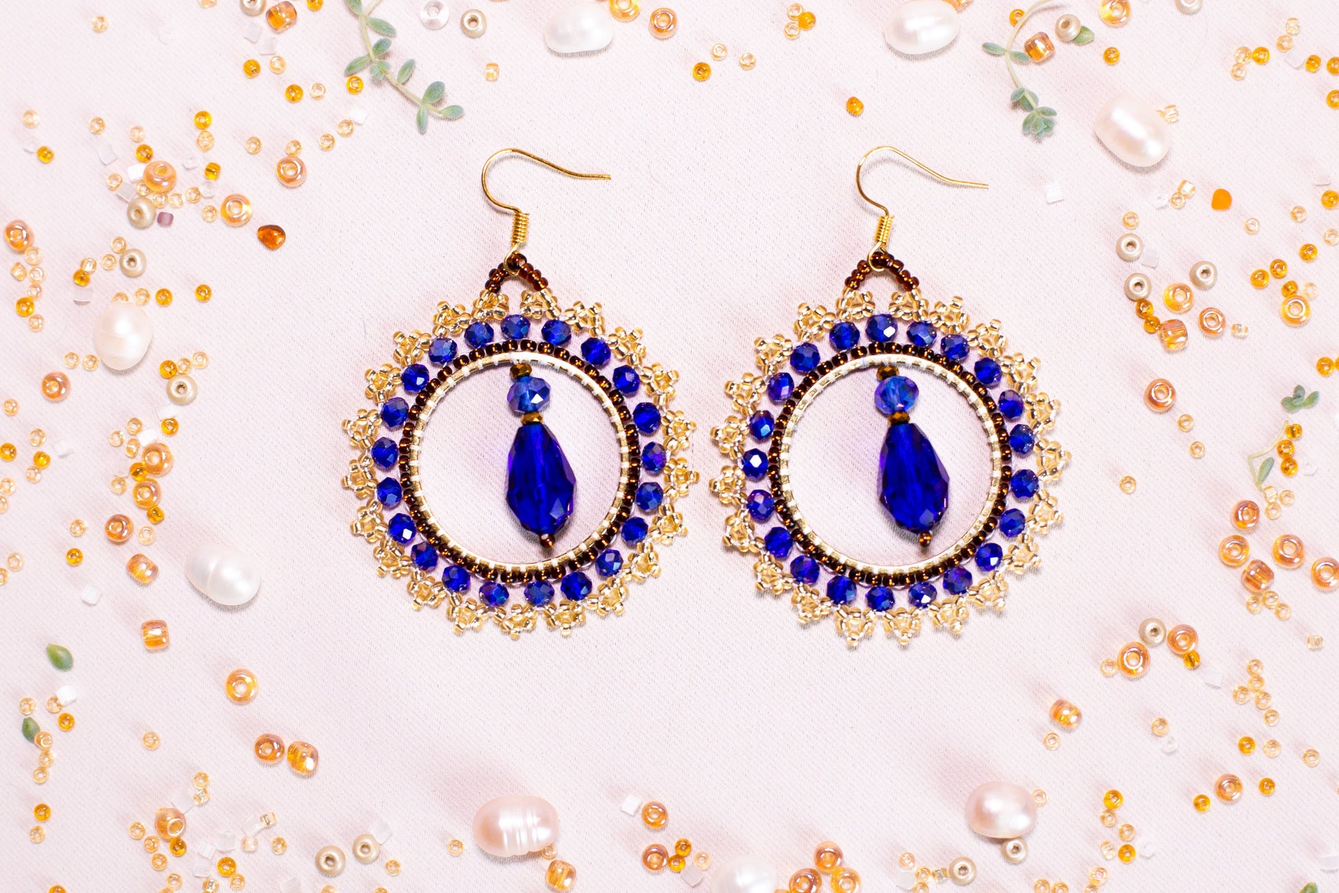 a pair of blue and white earrings on a table