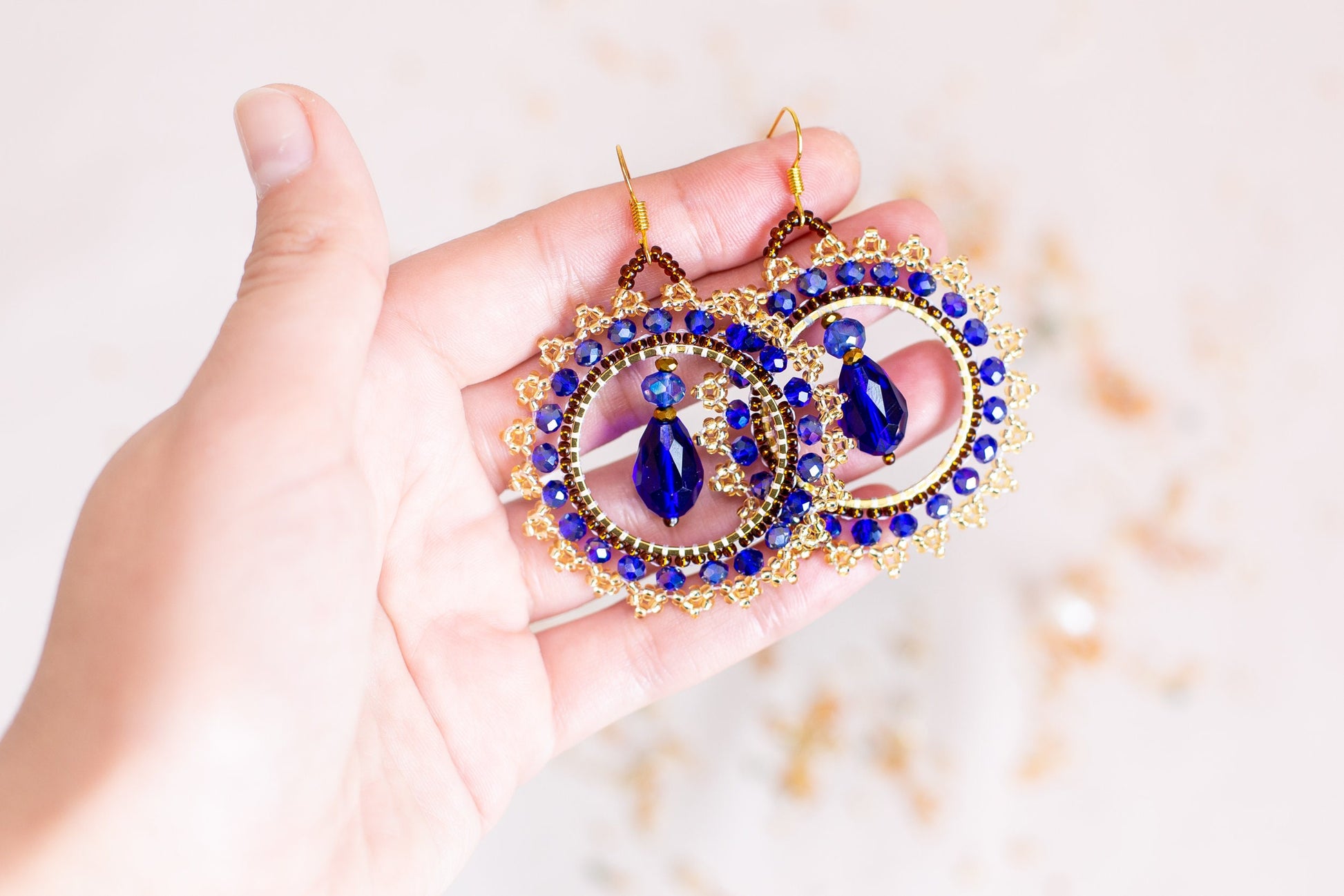 a person holding a pair of earrings in their hand