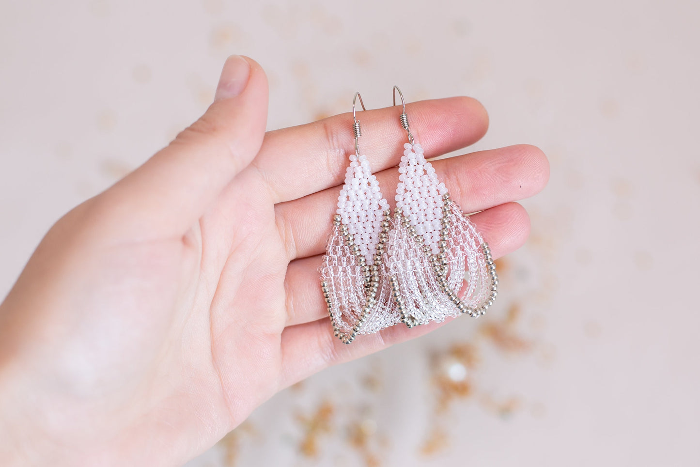 a person holding a pair of earrings in their hand