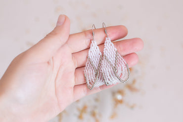 a person holding a pair of earrings in their hand