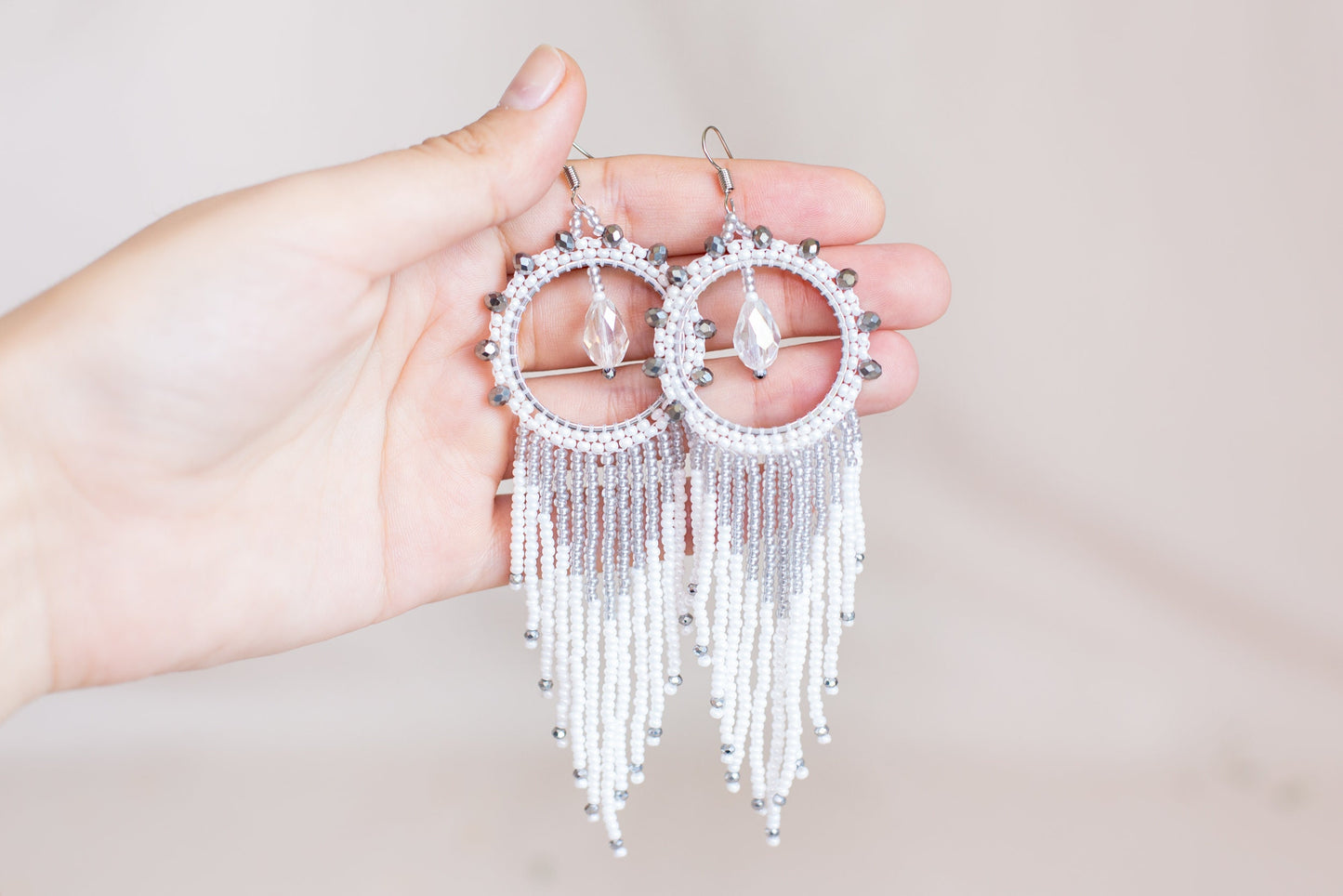 a person holding a pair of earrings in their hand