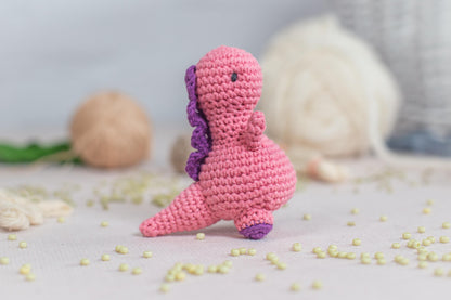 a pink crocheted toy sitting on top of a table