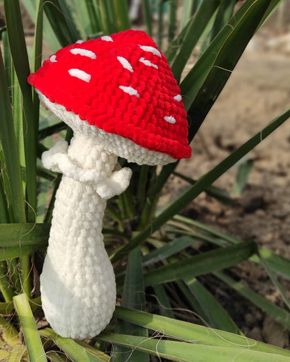 a crocheted mushroom sitting on top of a plant