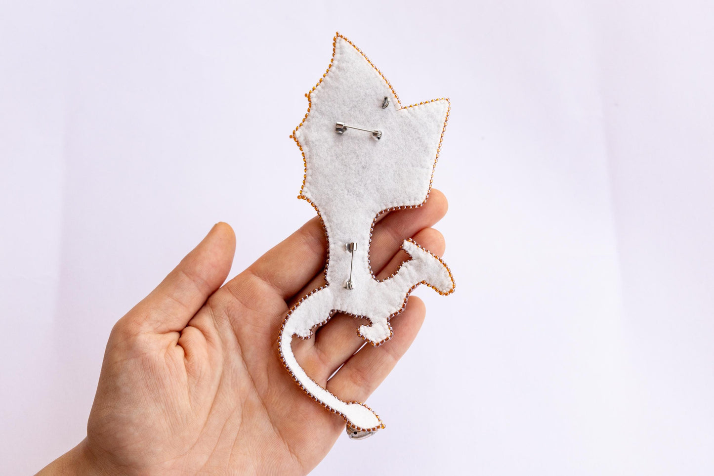 a person is holding a brooch in their hand