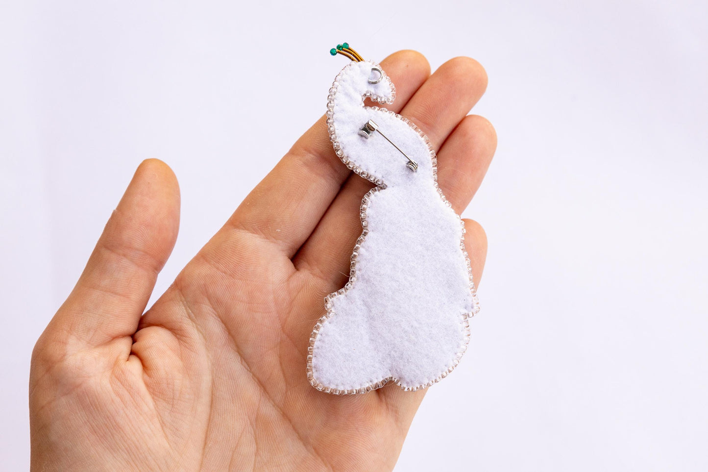 a hand holding a small white object in it&#39;s palm