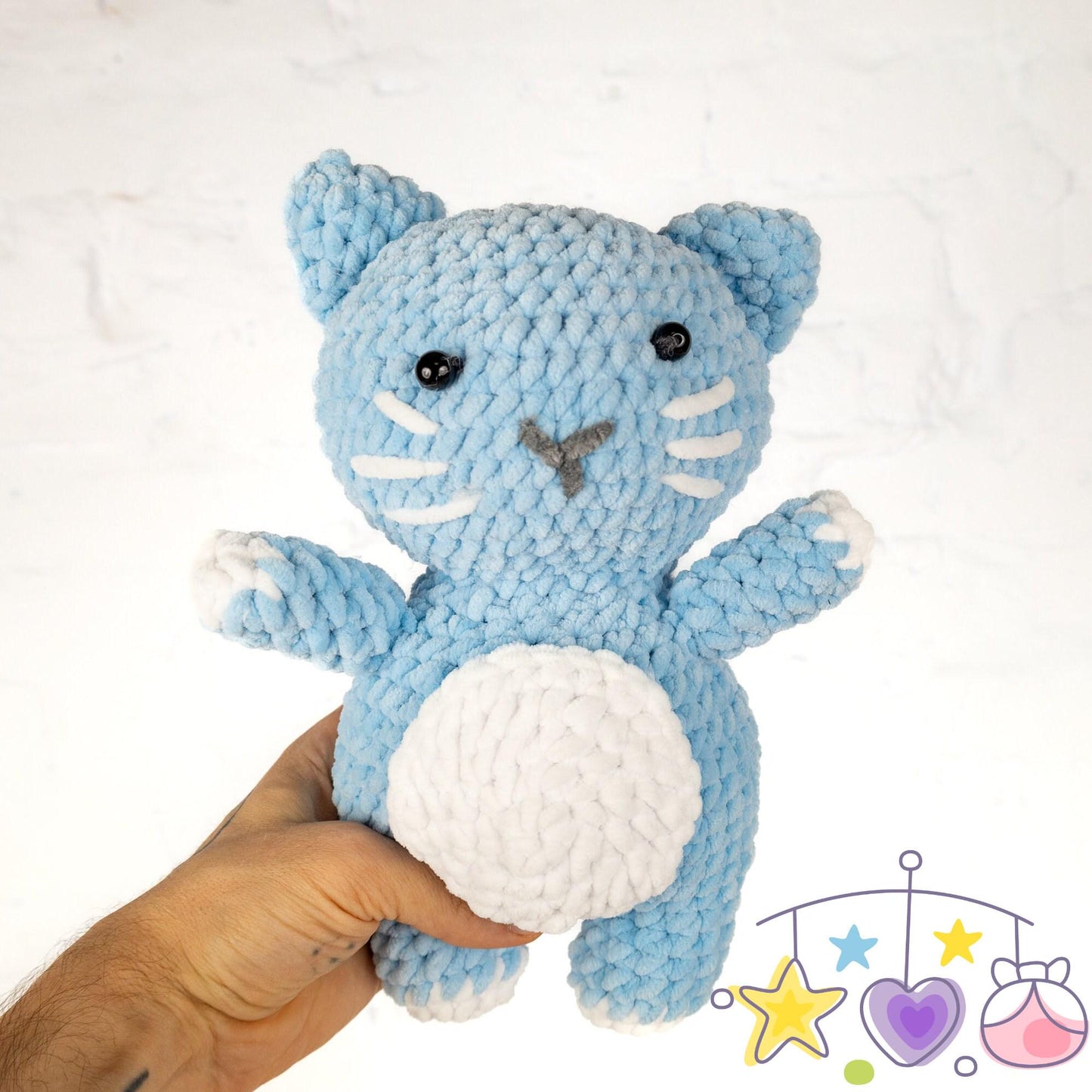 a crocheted cat is next to a ball of yarn