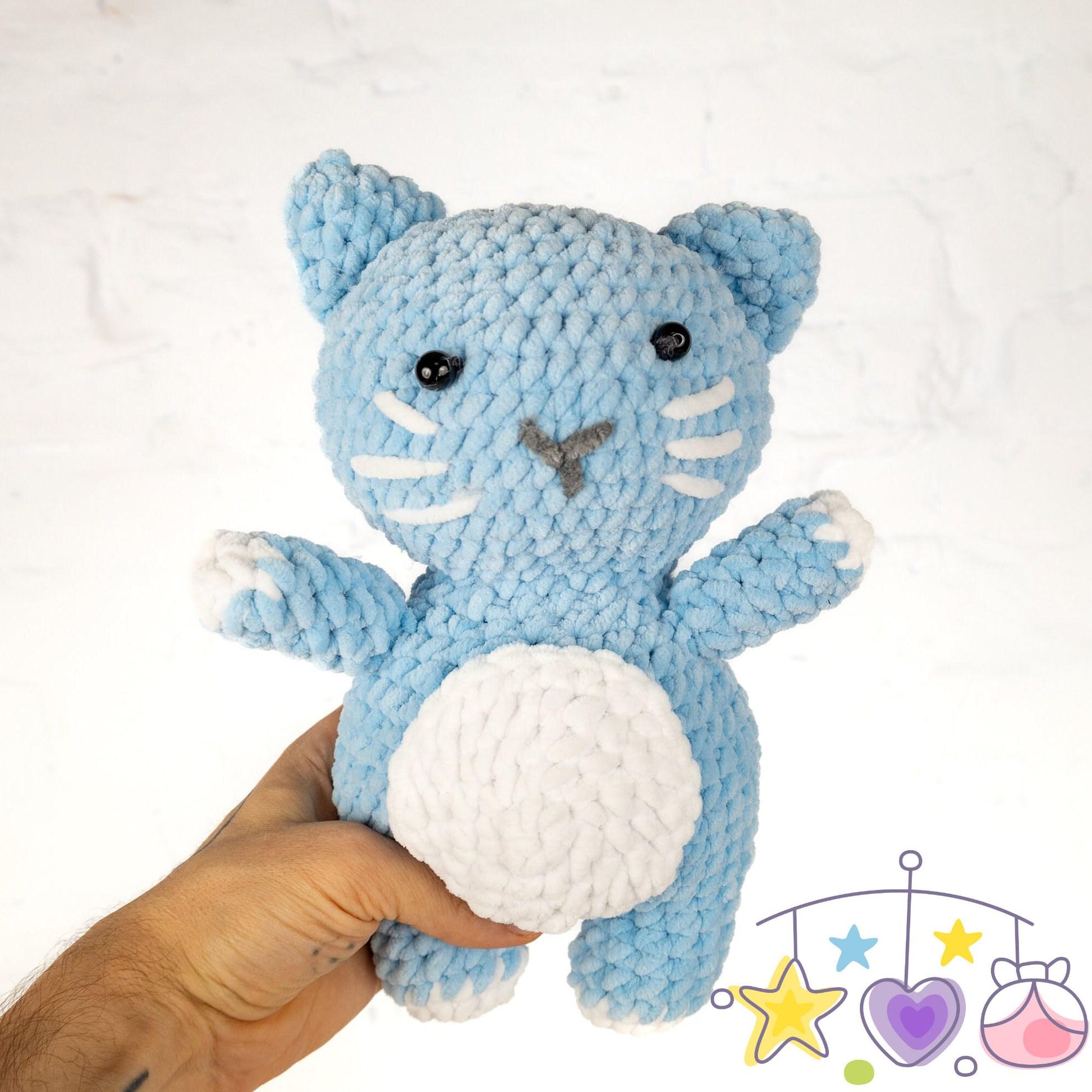 a crocheted cat is next to a ball of yarn