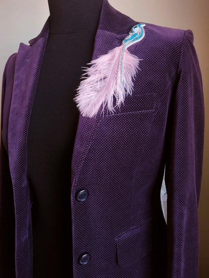 A purple velvet jacket with a feather pin on the left side.