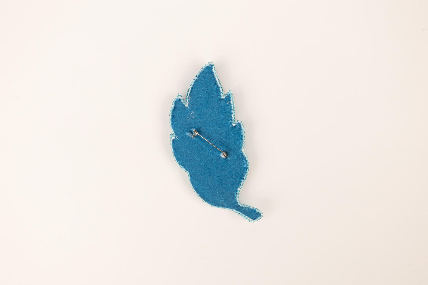 a blue piece of paper with a needle sticking out of it