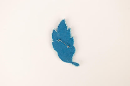 a blue piece of paper with a needle sticking out of it