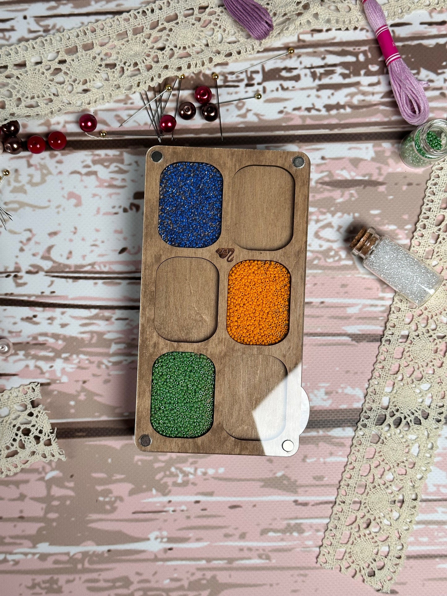 a wooden box with different colors of beads