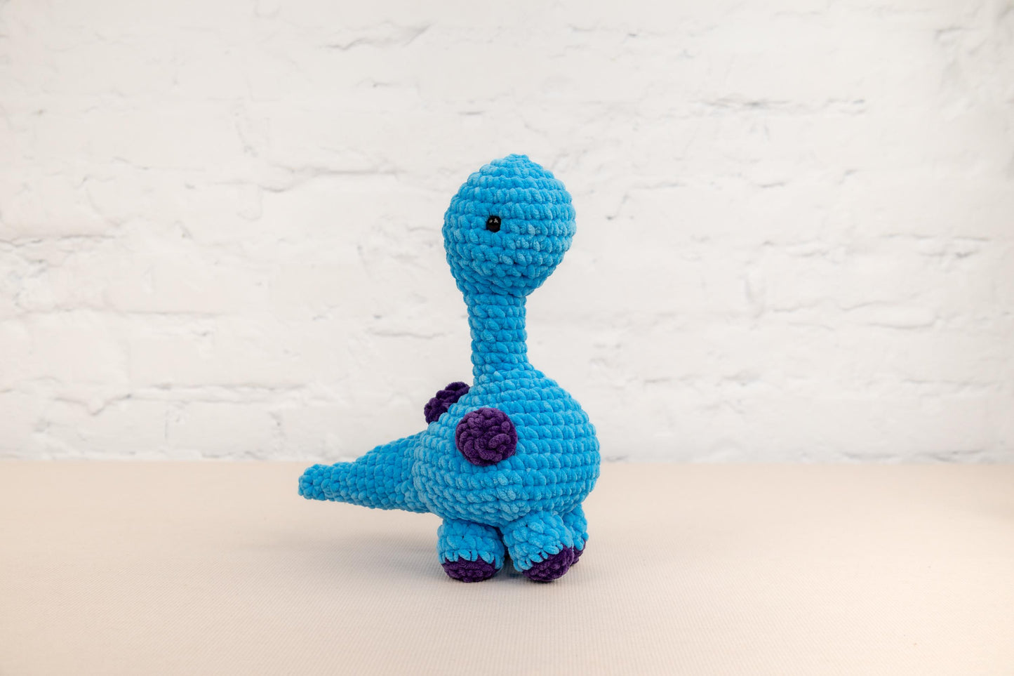 a crocheted blue toy sitting on top of a table