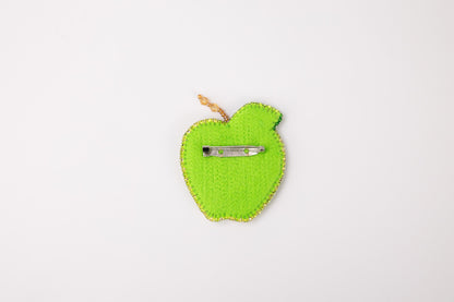 a green apple with a pair of scissors in it